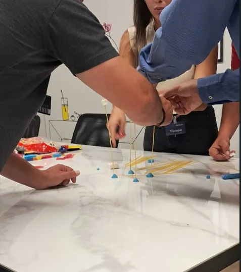 Equipe construindo torre durante atividade prática